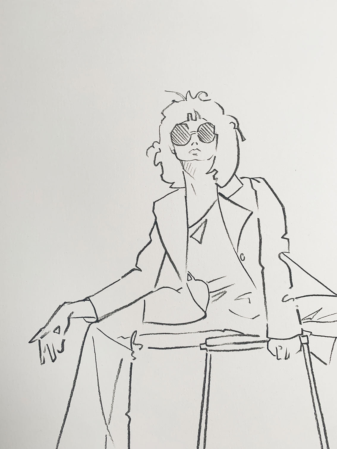 Details of a lady wearing a suit and sunglasses in a charcoal fashion illustration by Melanie Walker.